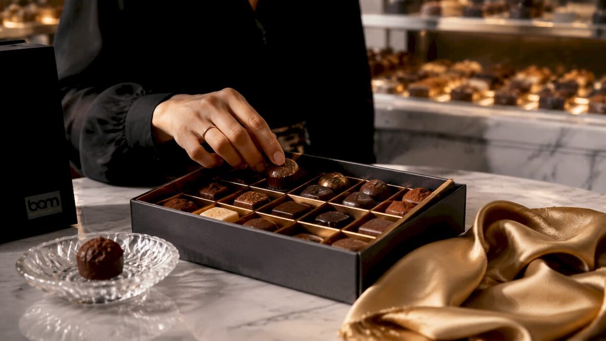 Cioccolatini assortiti in confezione regalo aperta con guida ai gusti